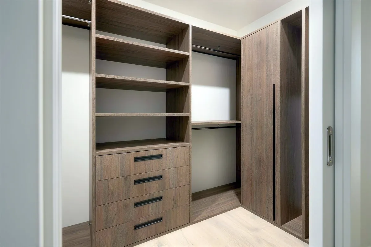 Walk-in closet with oak shelving, drawers and hanging space