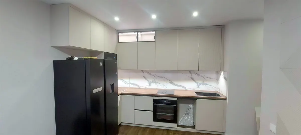 Kitchen with handleless cabinets and a marble-look backsplash