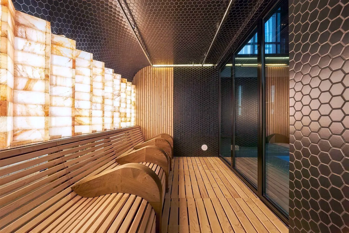 Relaxation room with a backlit salt-brick wall and wood loungers