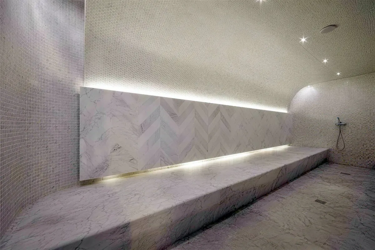 Hammam with a heated marble bench and mosaic walls