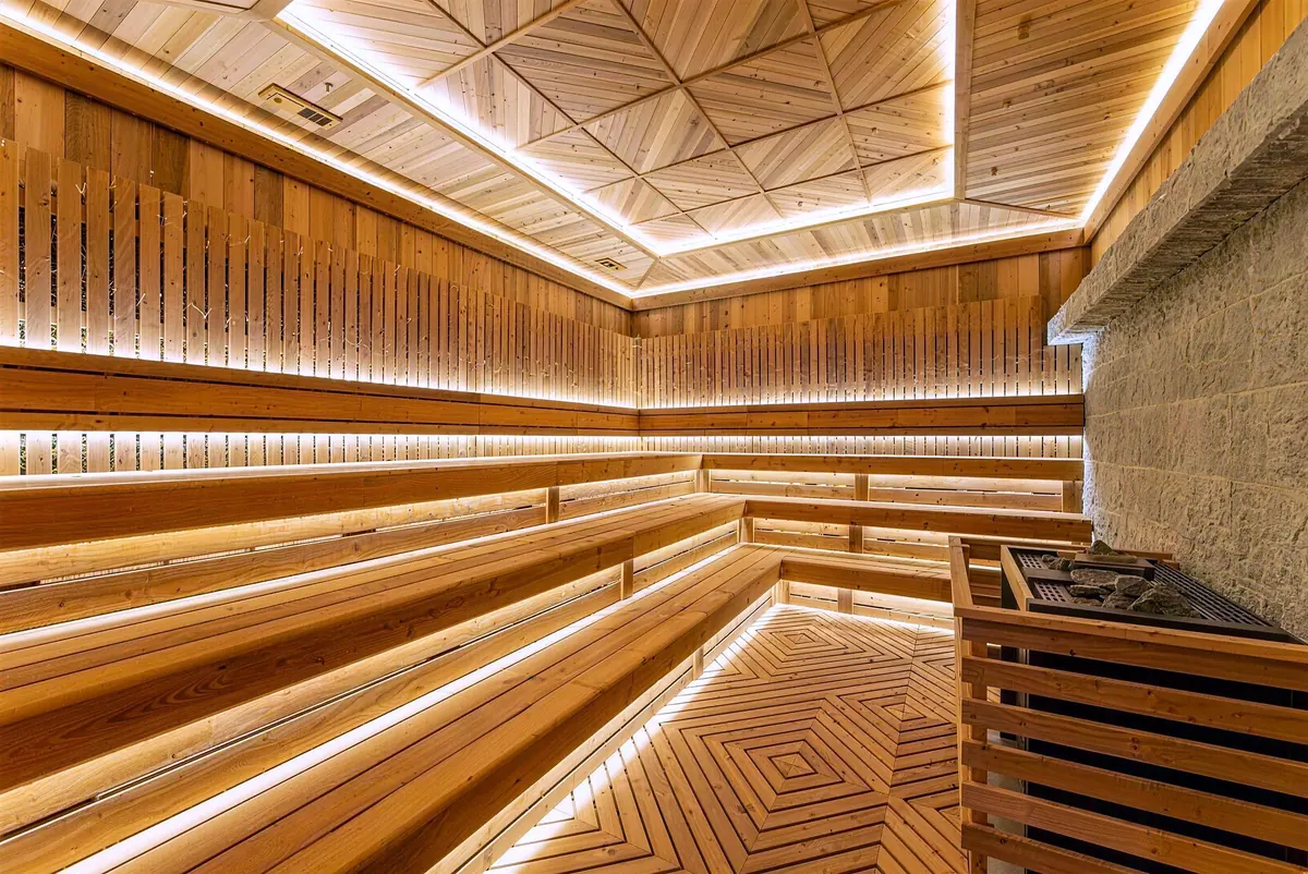Wood sauna with LED-lit benches and a geometric ceiling