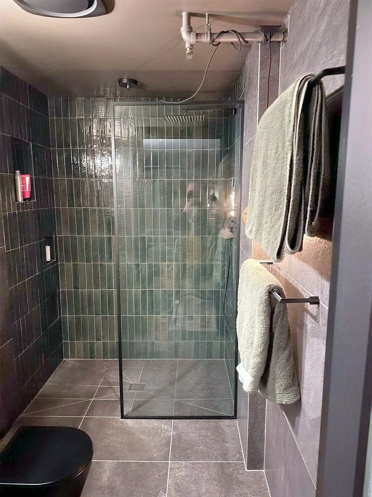 Remodeled Marina del Rey bathroom: green tile shower behind a glass panel, with towel bars