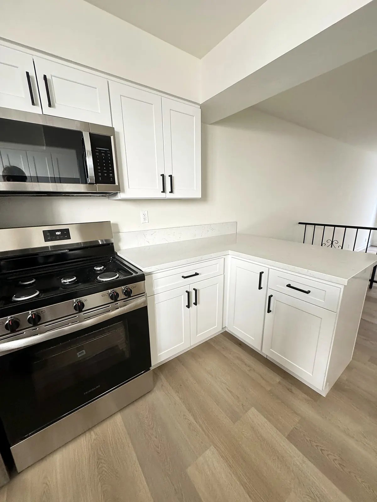 Remodeled townhouse kitchen in Sherman Oaks with white shaker cabinets and a stainless gas range