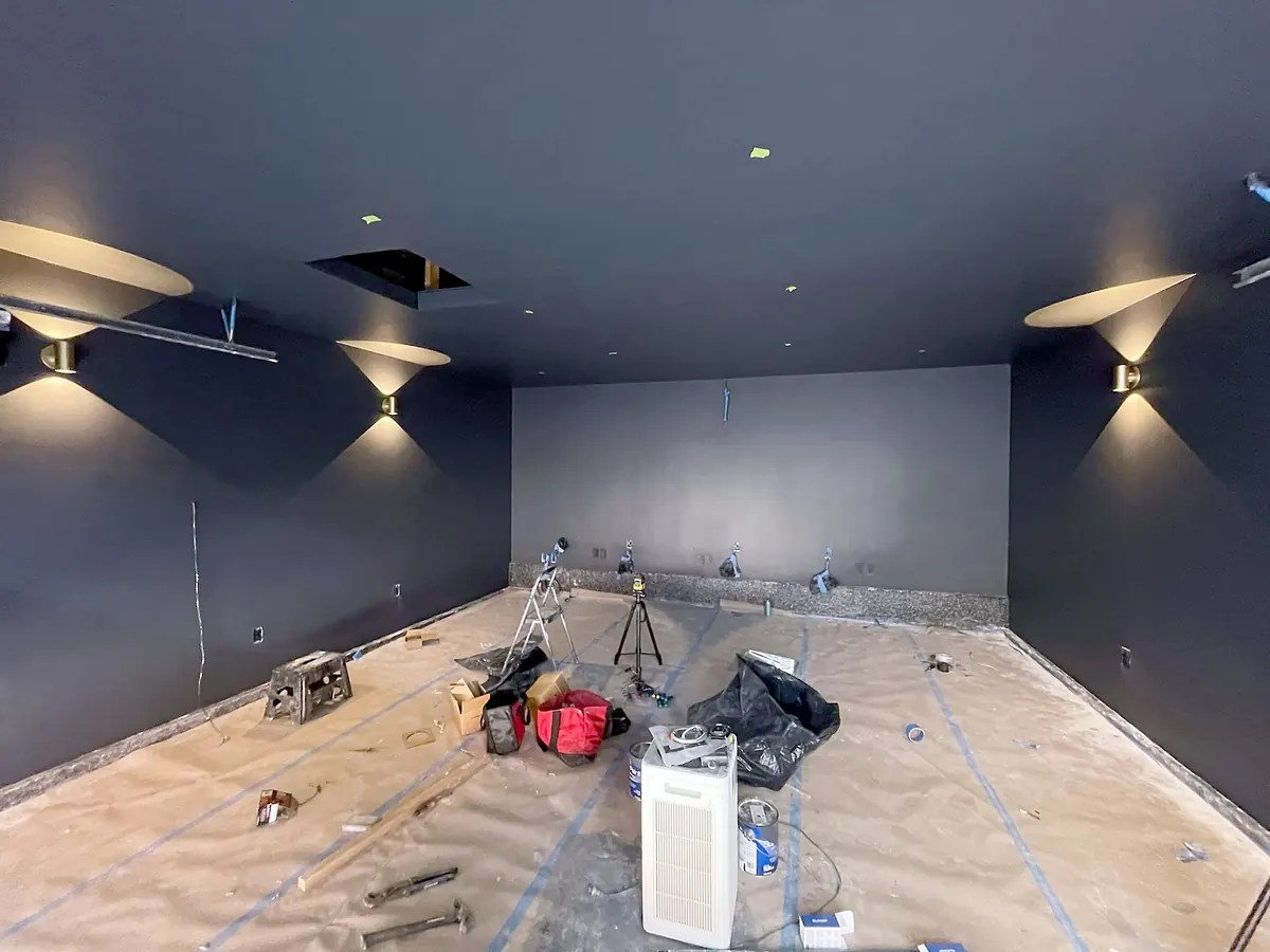 Charcoal walls and ceiling with wall sconces in the converted garage